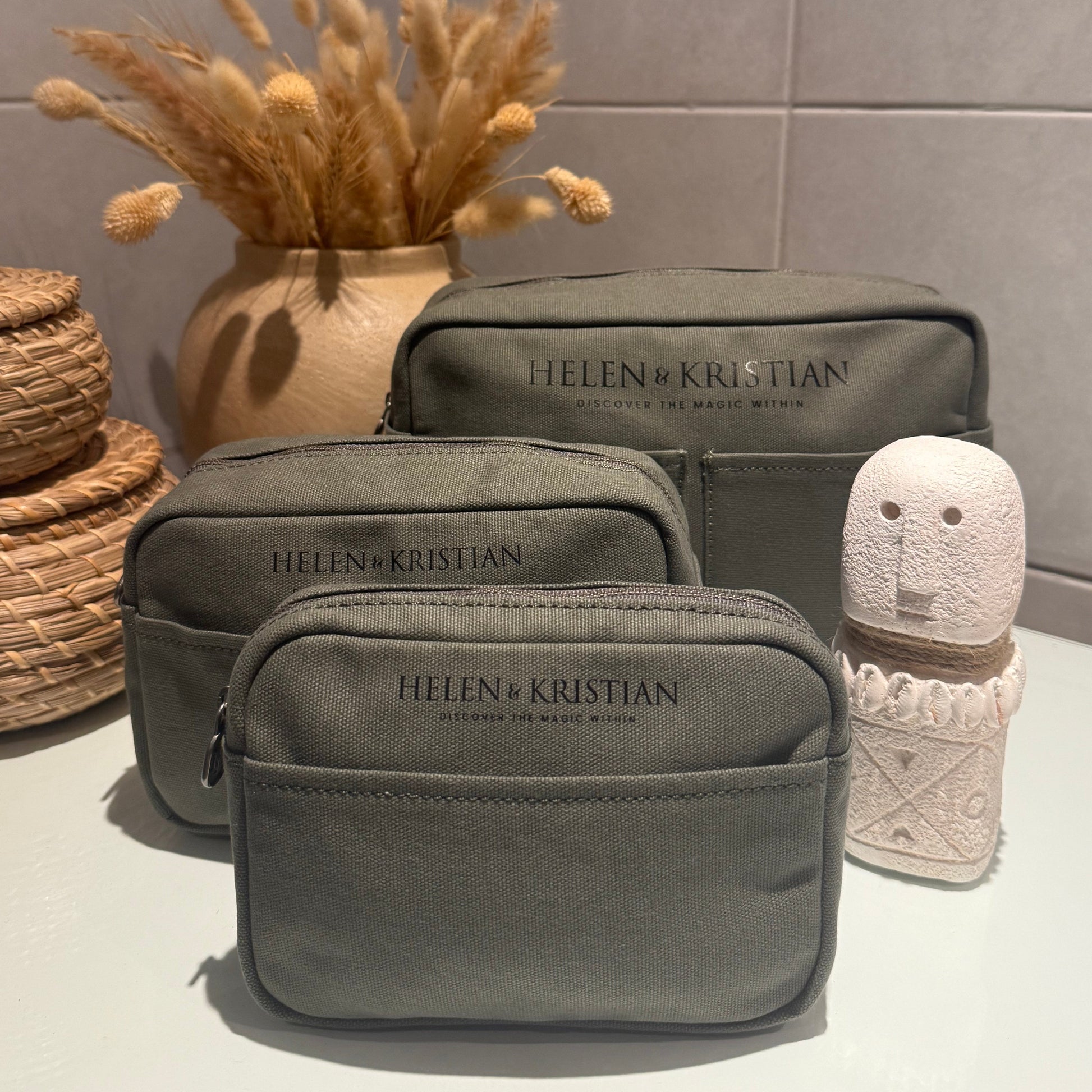Set of green cosmetic bags with 'HELEN & Kristian' branding on a neutral background.
