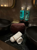 Nesty Roasted Chestnut petite trousse de toilette by Helen & Kristian on elegant bathroom counter.