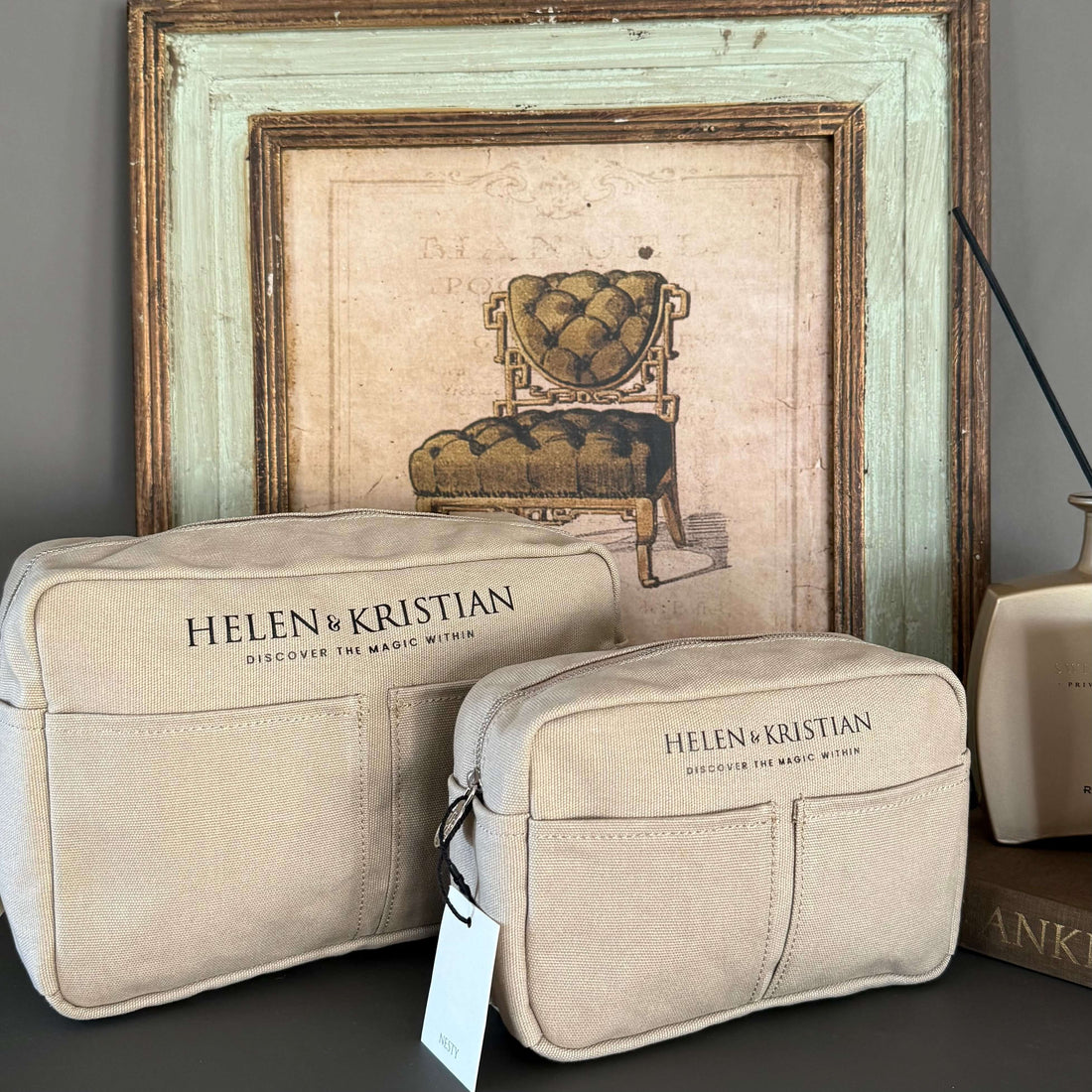 Nesty - Small Toiletry bag - Viking Haze displayed on a table beside a decorative lamp and floral wallpaper.