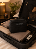 Nesty - Stor Toalettmappe - Black Raven packed in a stylish suitcase with cozy essentials nearby.