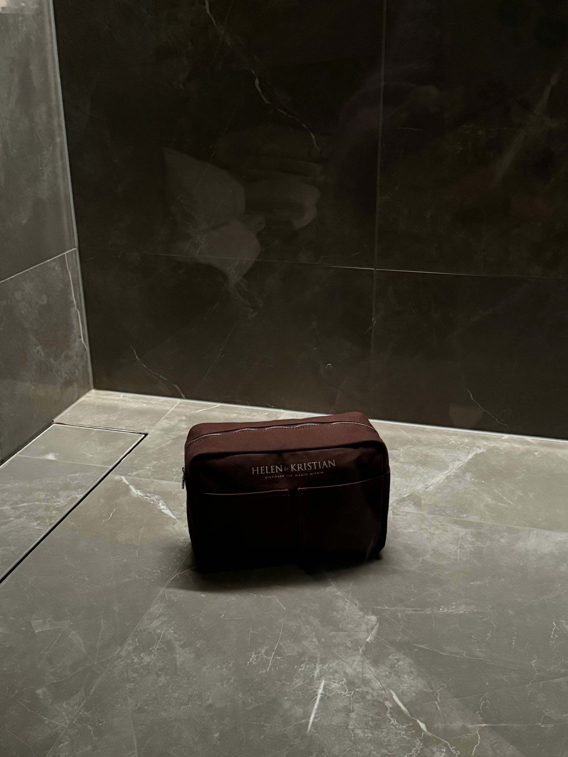 Nesty Roasted Chestnut Large Toiletry Bag by Helen & Kristian on a sleek marble surface.