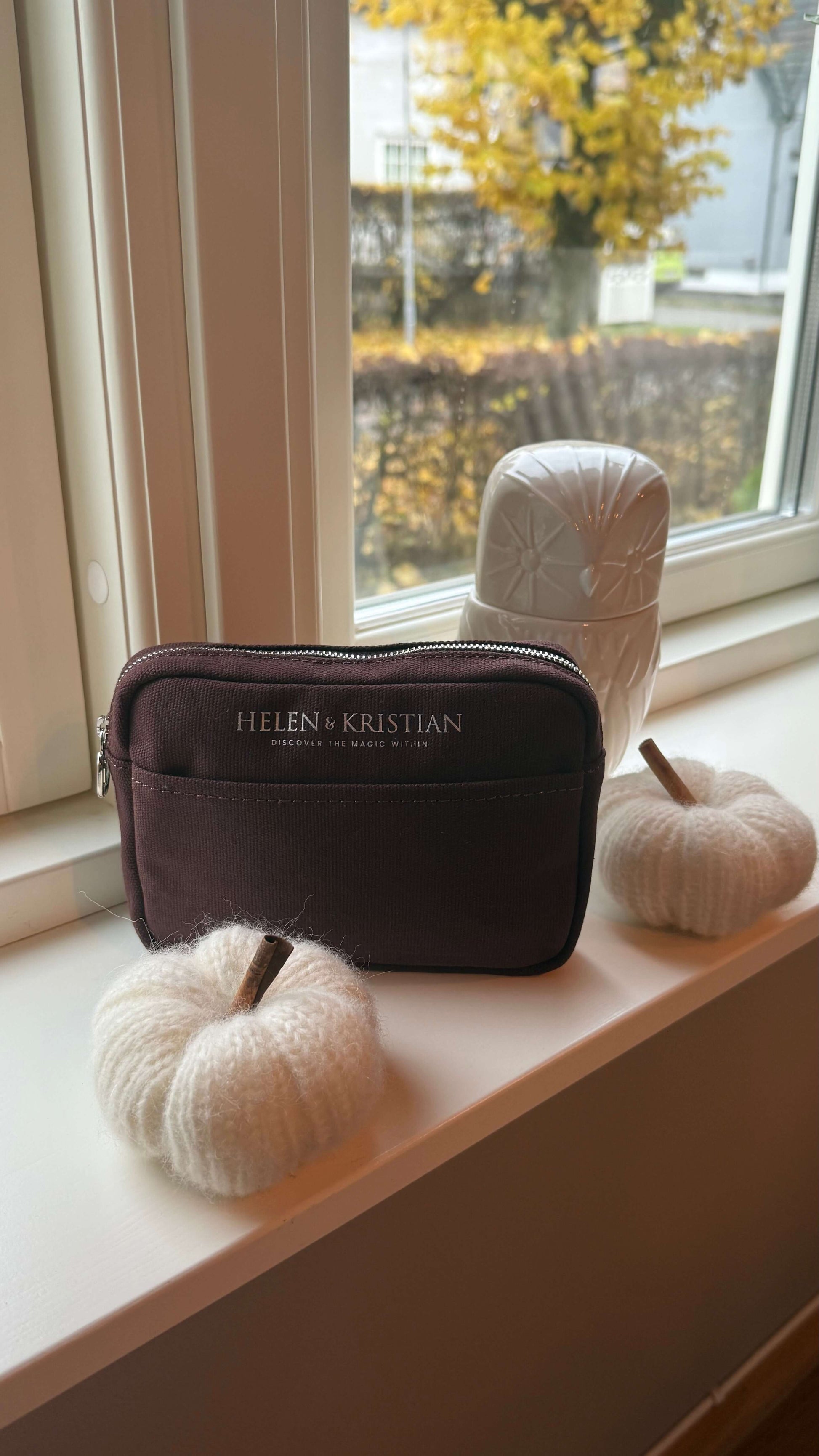 Clutch Nipsy Roasted Chestnut displayed on a windowsill with decorative white pumpkins, offering elegant organization for essentials.