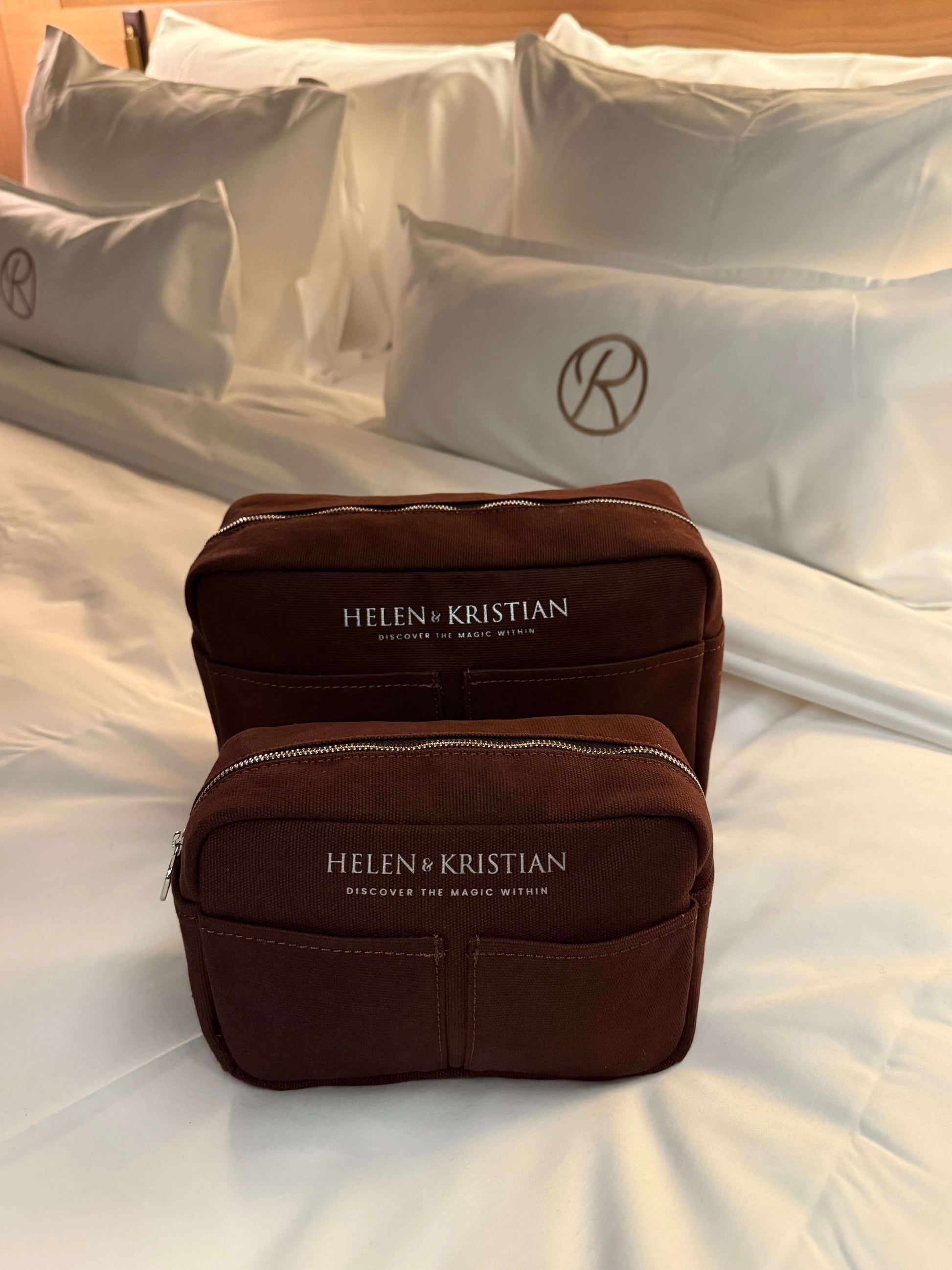 Nesty Roasted Chestnut petite trousse de toilette by Helen & Kristian on a bed, showcasing elegant design and functionality.