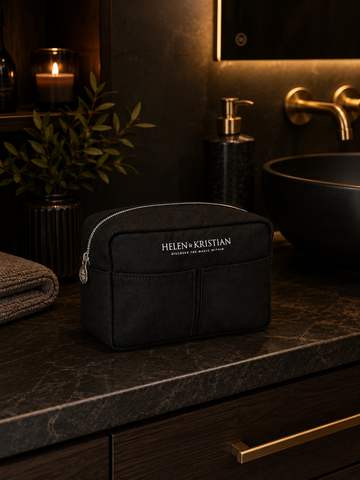 Nesty - Stor Toalettmappe - Black Raven on a marble bathroom countertop with candles and plant decor.
