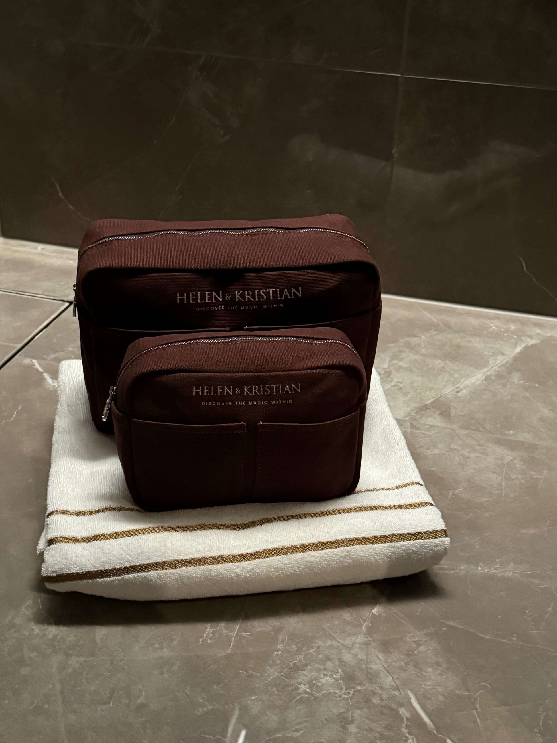 Nesty Roasted Chestnut petite trousse de toilette by Helen & Kristian on a towel, showcasing elegant and functional design.