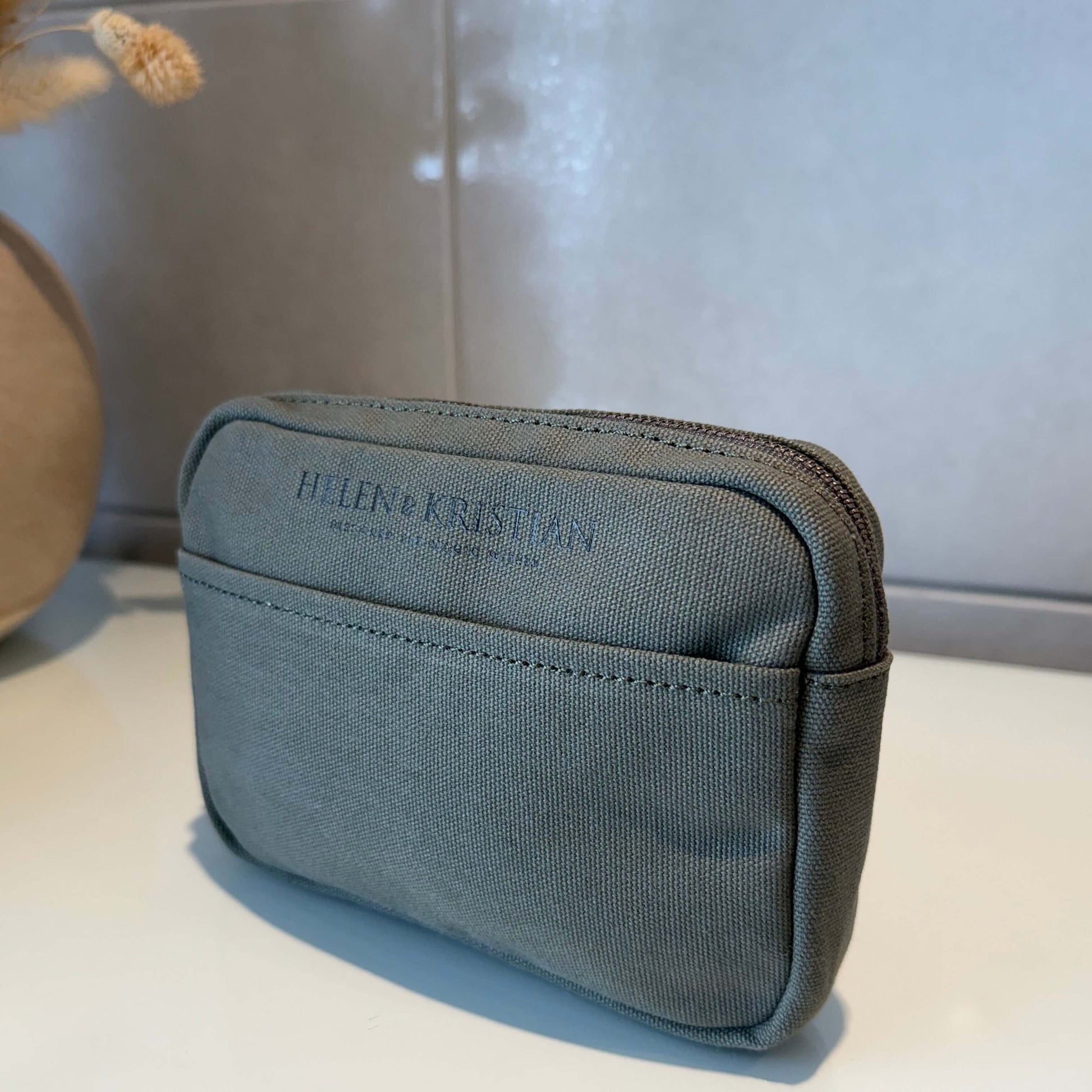 Green Cotton Clutch with 'Helen & Kristian' branding against a neutral background.
